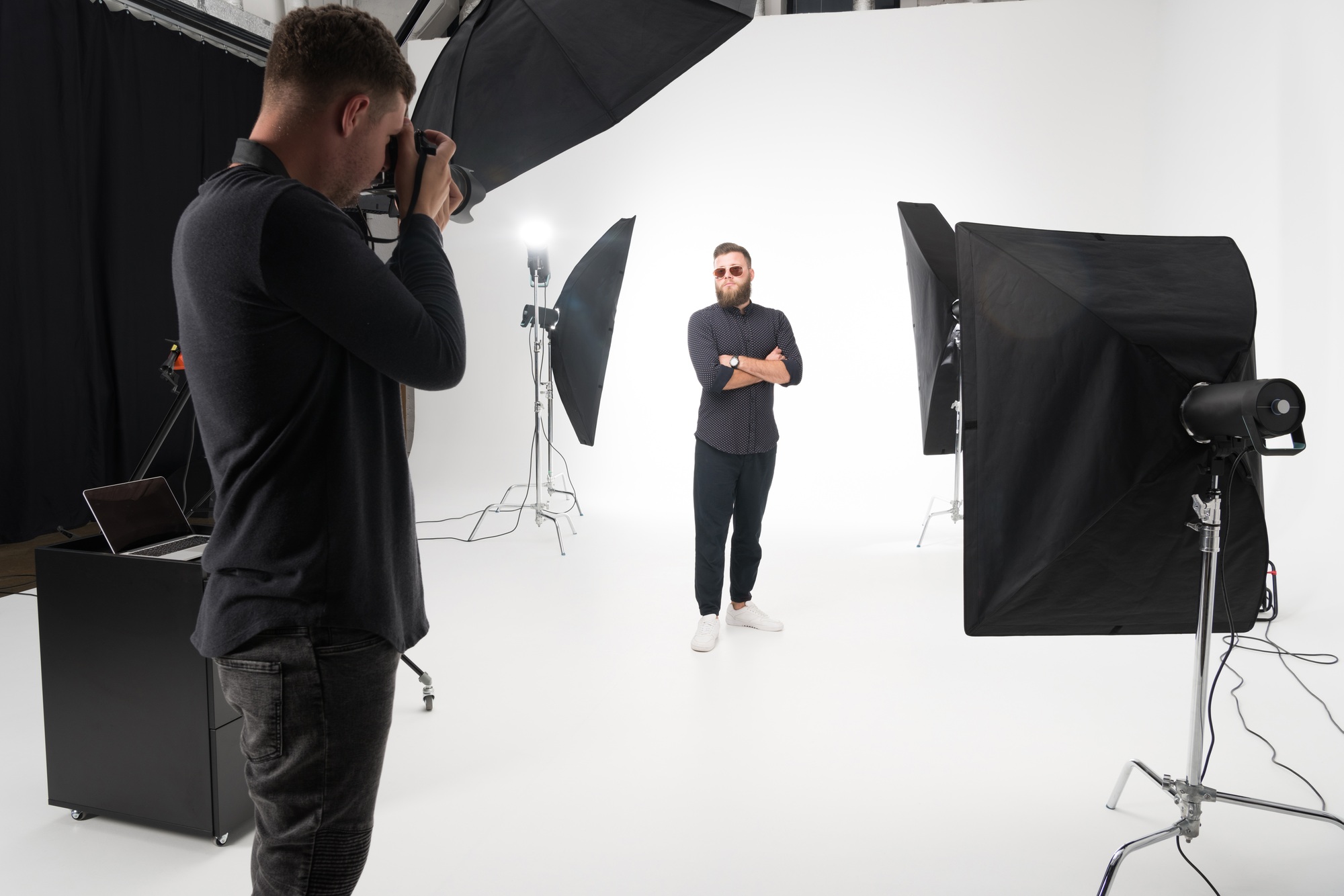 young photographer working together with model during photo session in studio young photographer working together with model during photo session in studio
